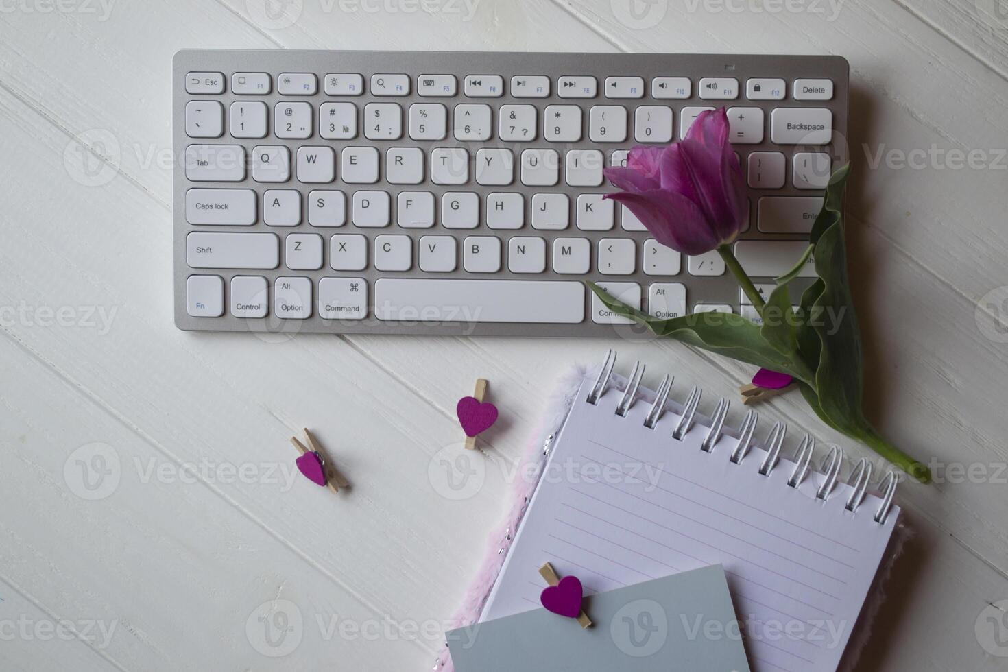 Computer keyboard and notebook with empty sheet. Modern workplace. photo