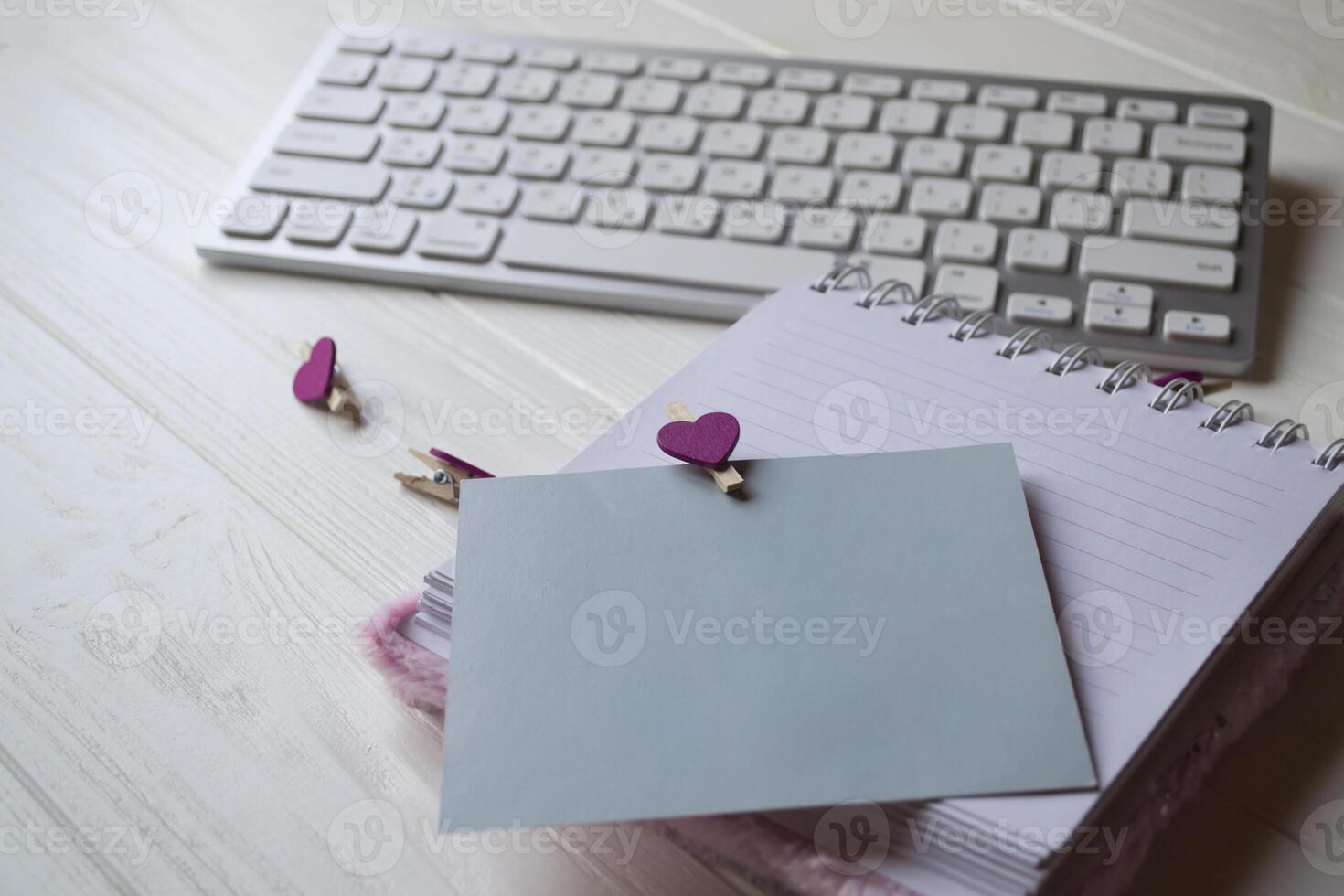 Computer keyboard and notebook with empty sheet. Modern workplace. photo