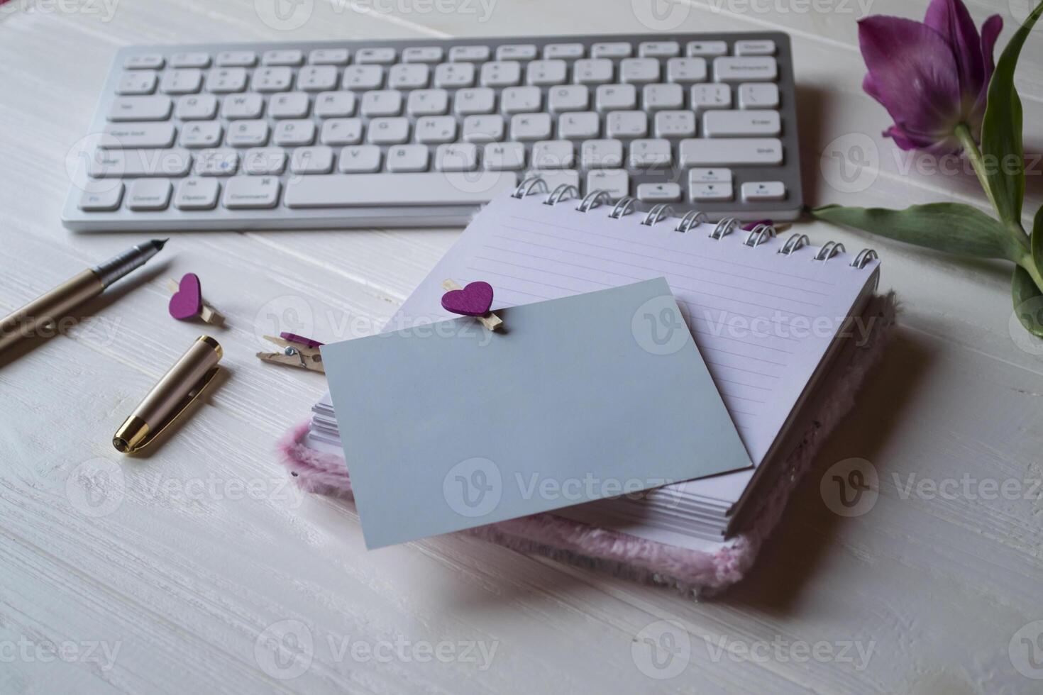 Computer keyboard and notebook with empty sheet. Modern workplace. photo