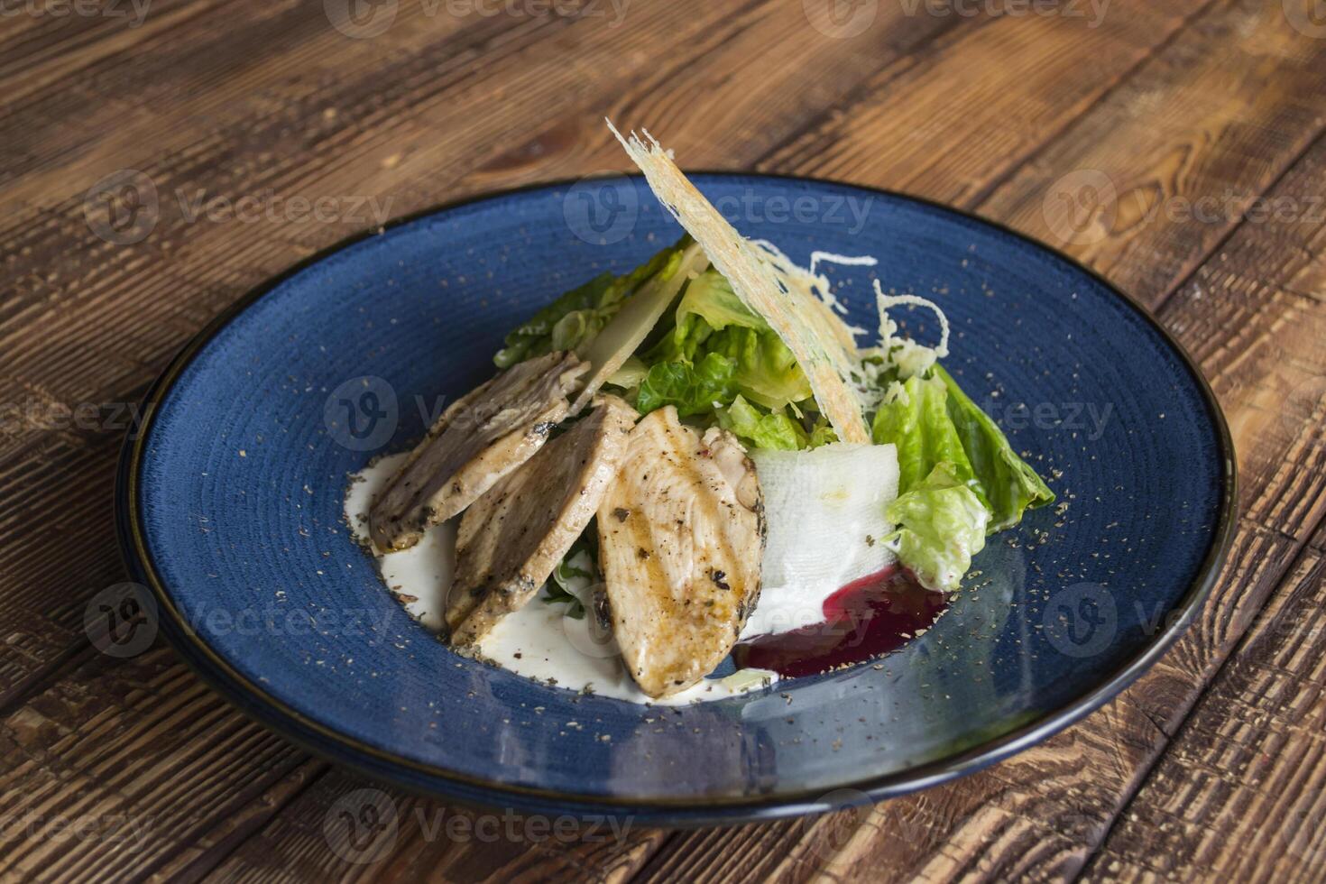 The hot salad with meat on a wooden background. photo