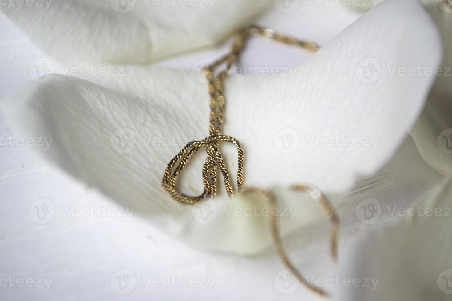 Golden chain on white petals photo