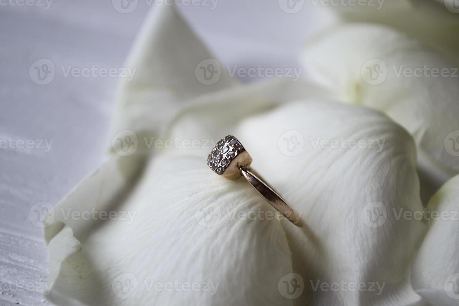 Golden ring on white petals of roses. photo