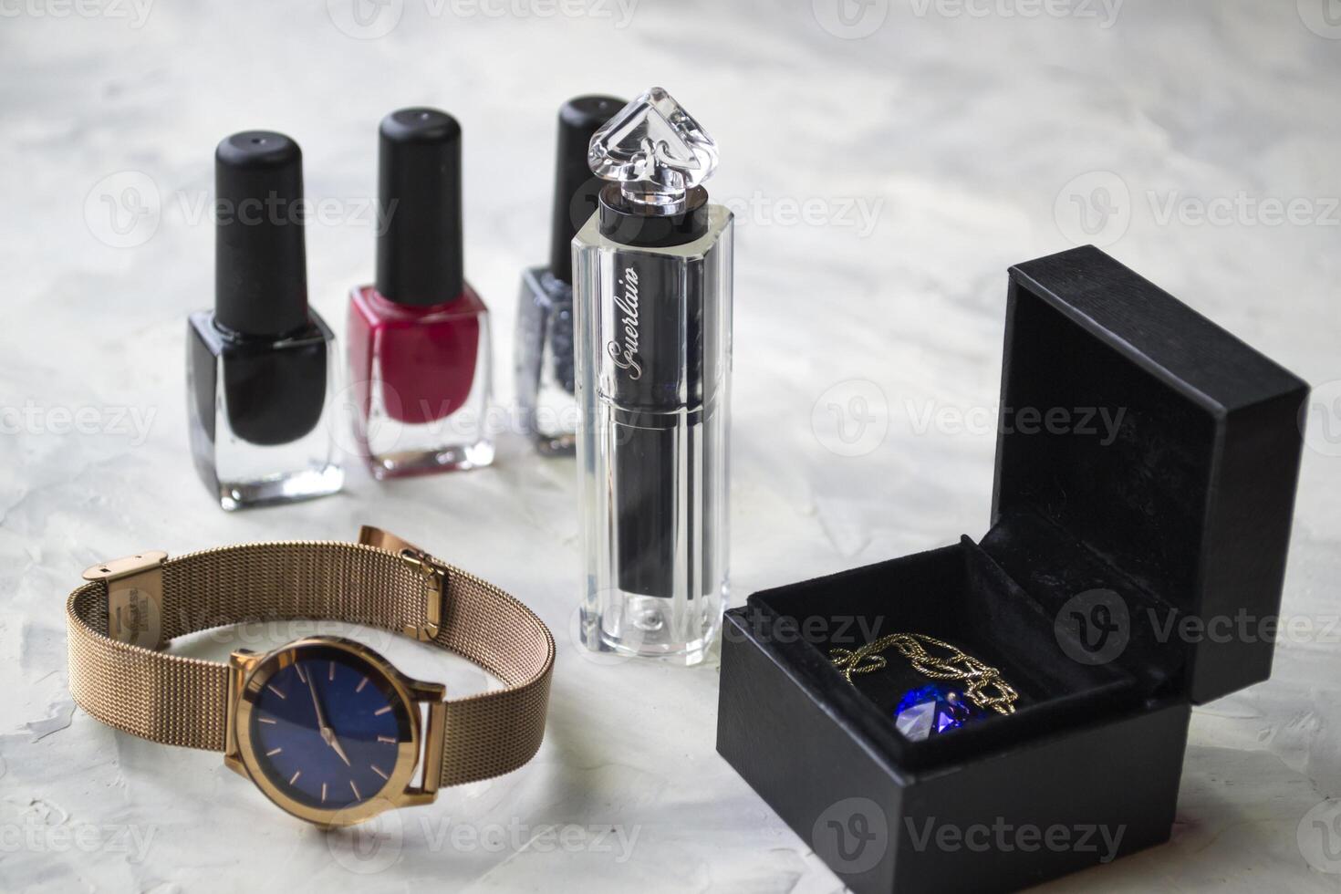 Wrist watch and female accessories on the table. photo