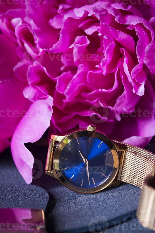 Female wrist watch and peony, close up. photo