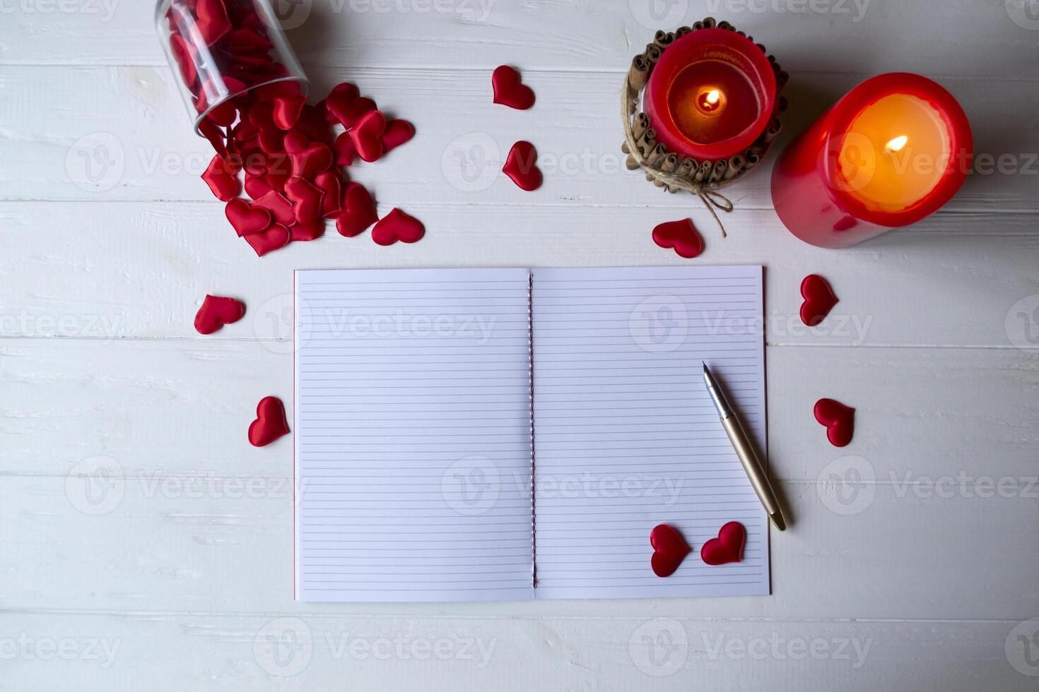 rojo velas, amor corazones y cuaderno en el mesa. hermosa fondo con Copiar espacio. foto