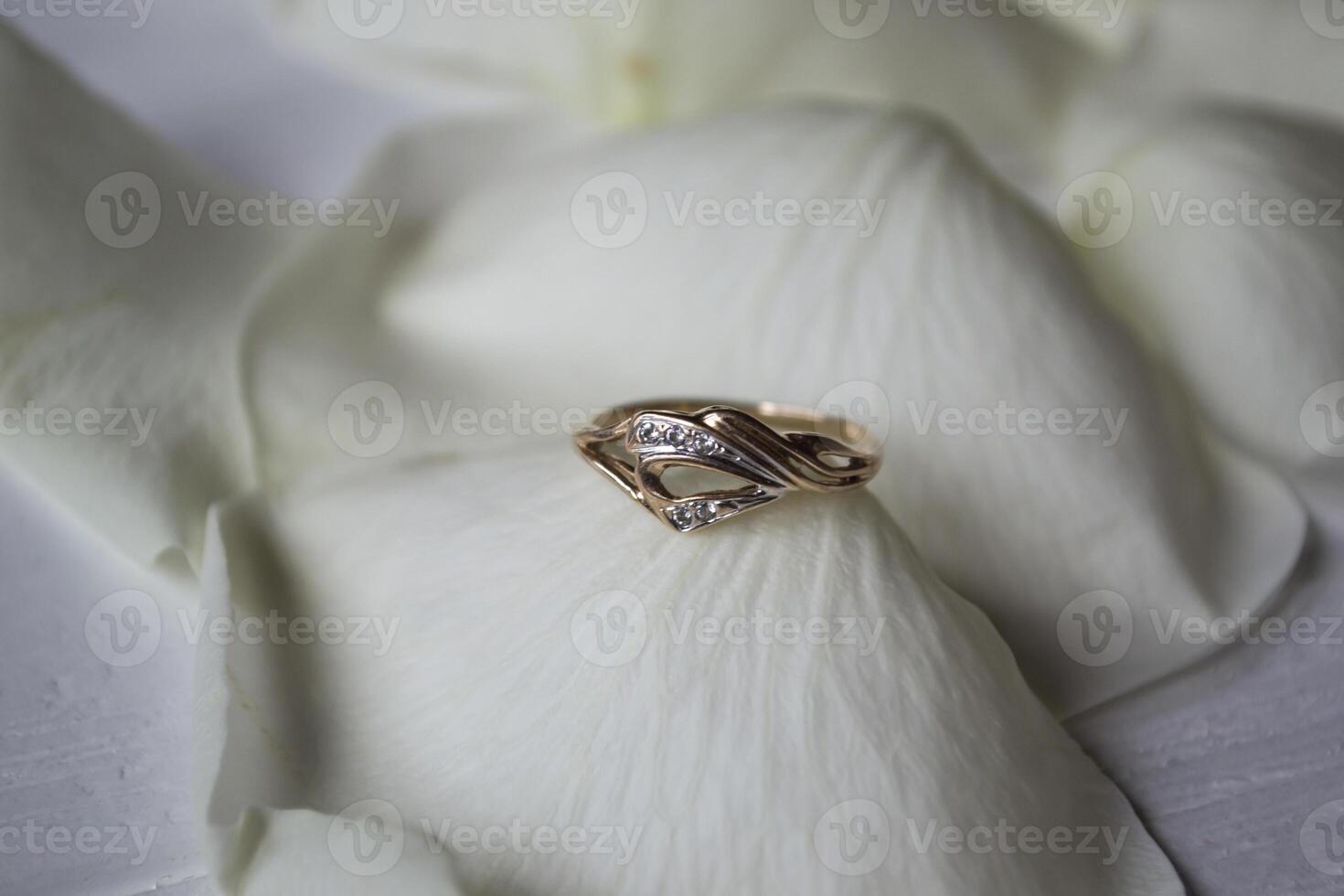 Golden ring on white petals of roses. photo