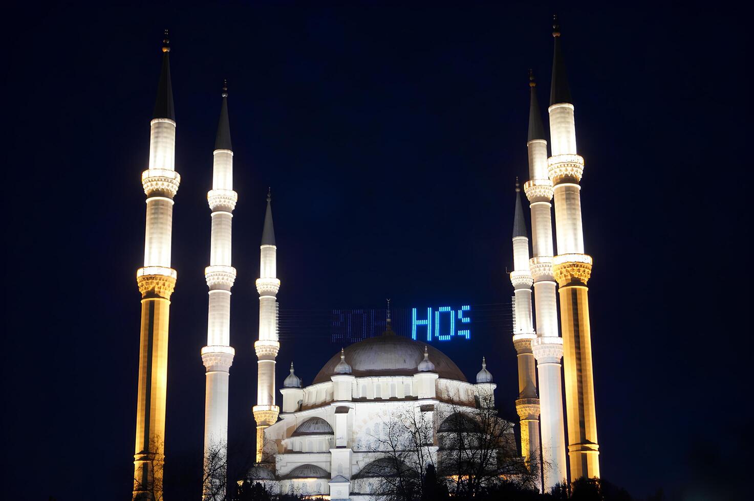 A large white mosque with blue letters photo
