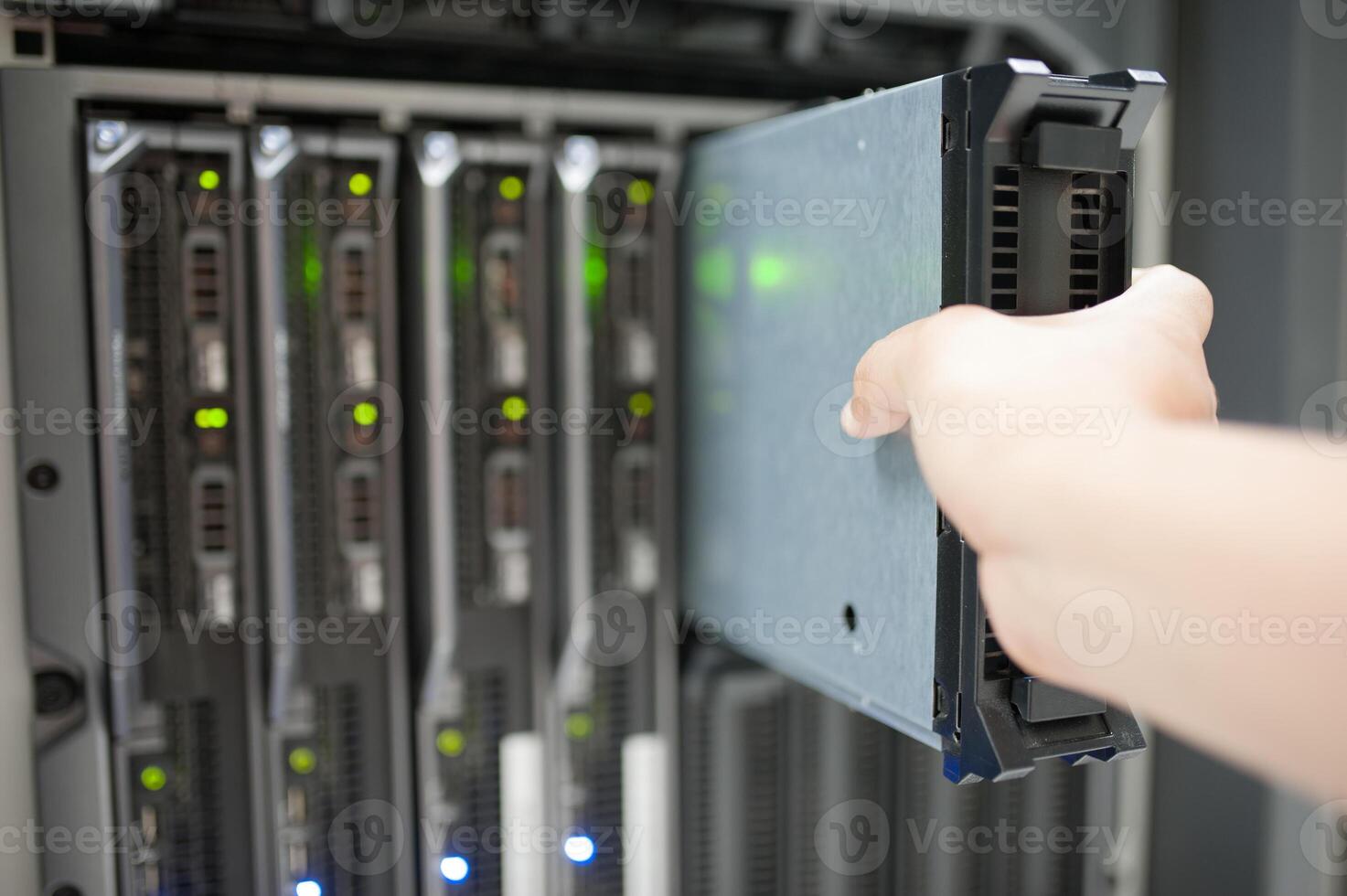 IT engineer repairing a server in a datacenter photo