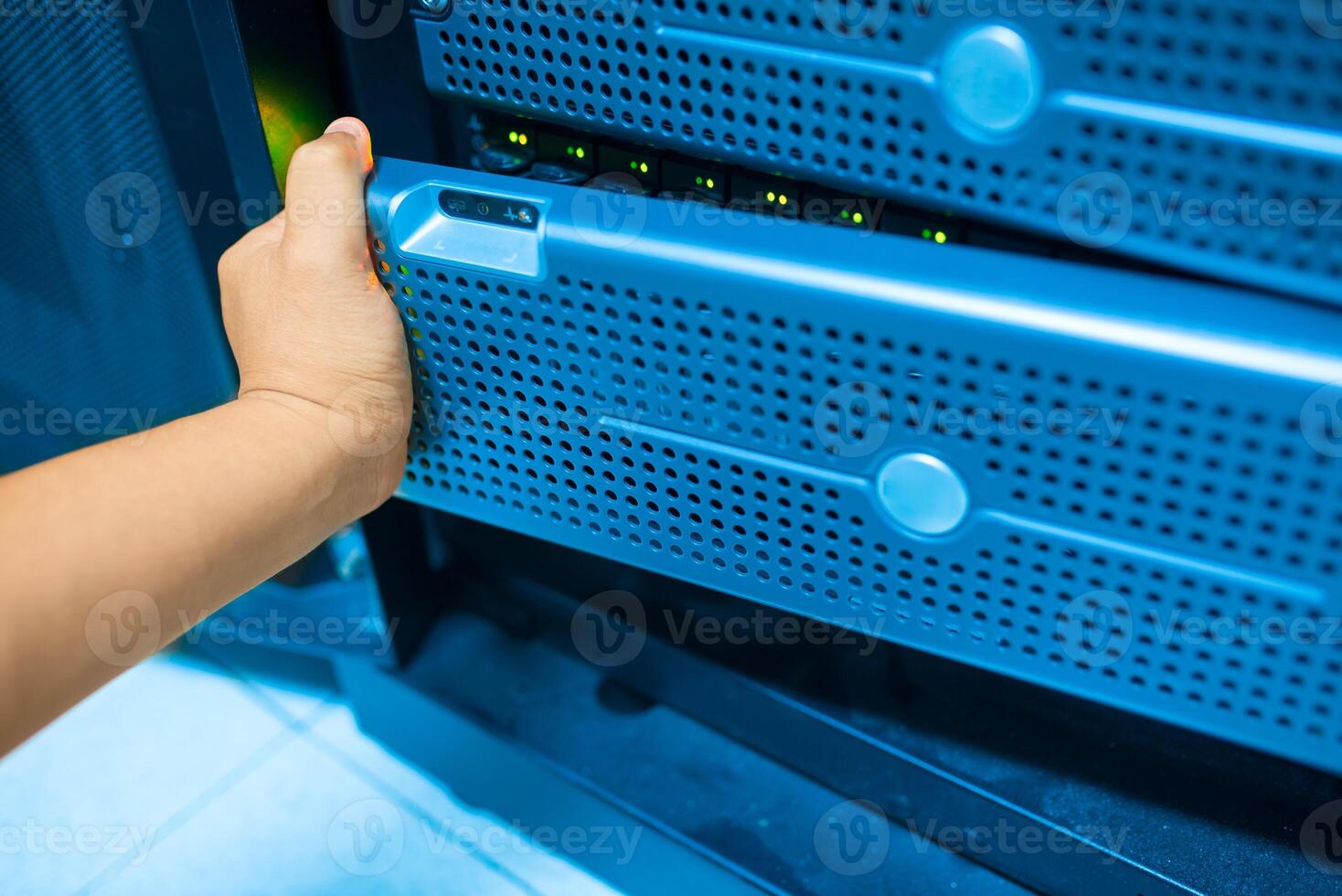 IT engineer repairing a server in a datacenter photo