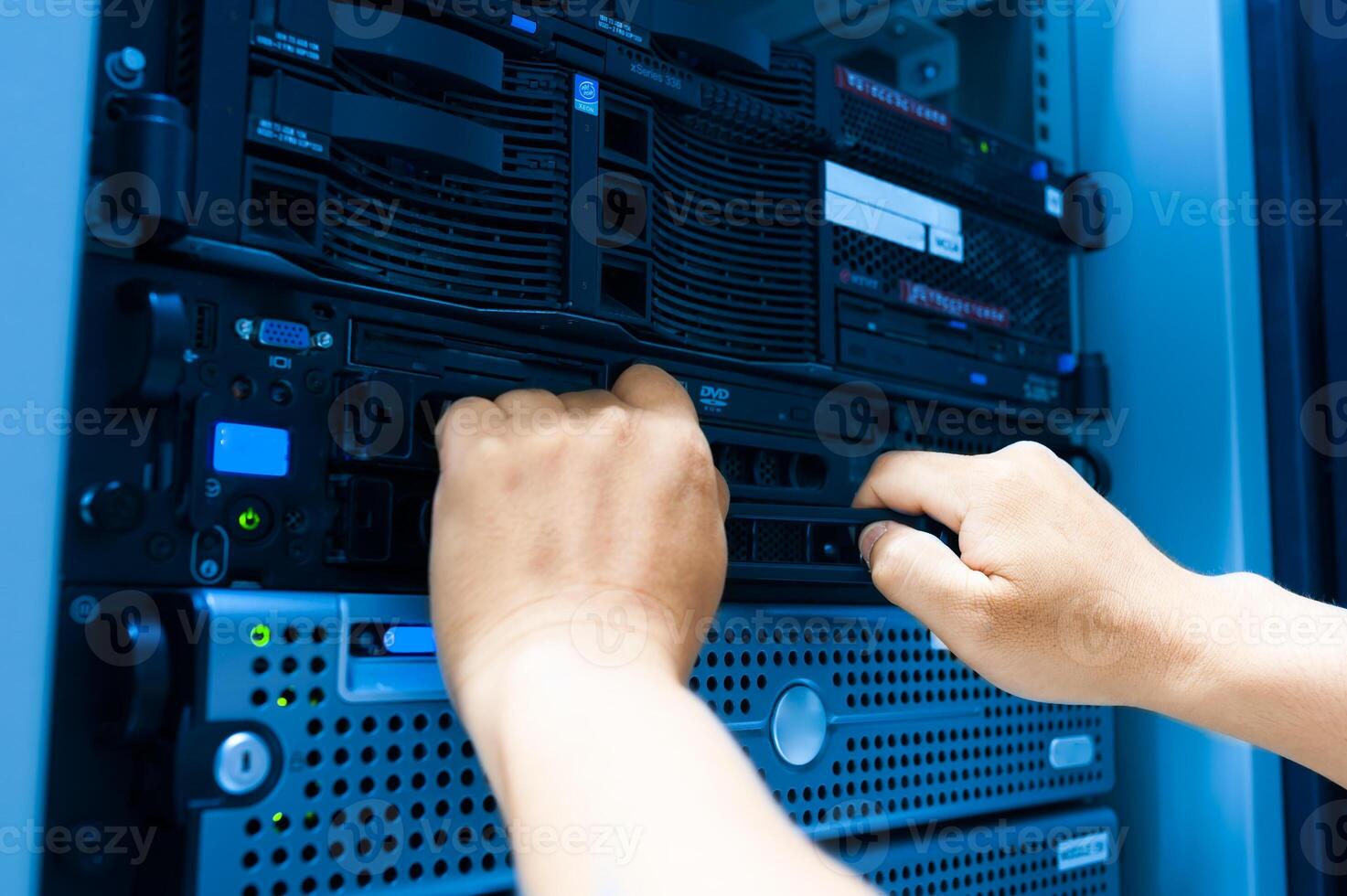 IT engineer repairing a server in a datacenter photo