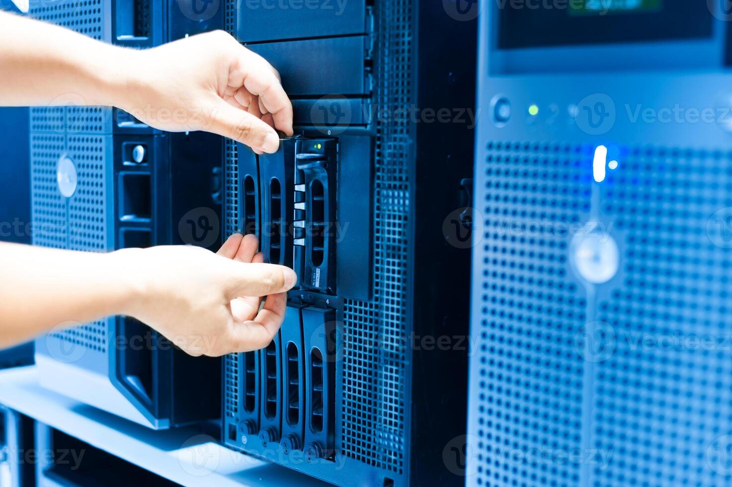 IT engineer repairing a server in a datacenter photo