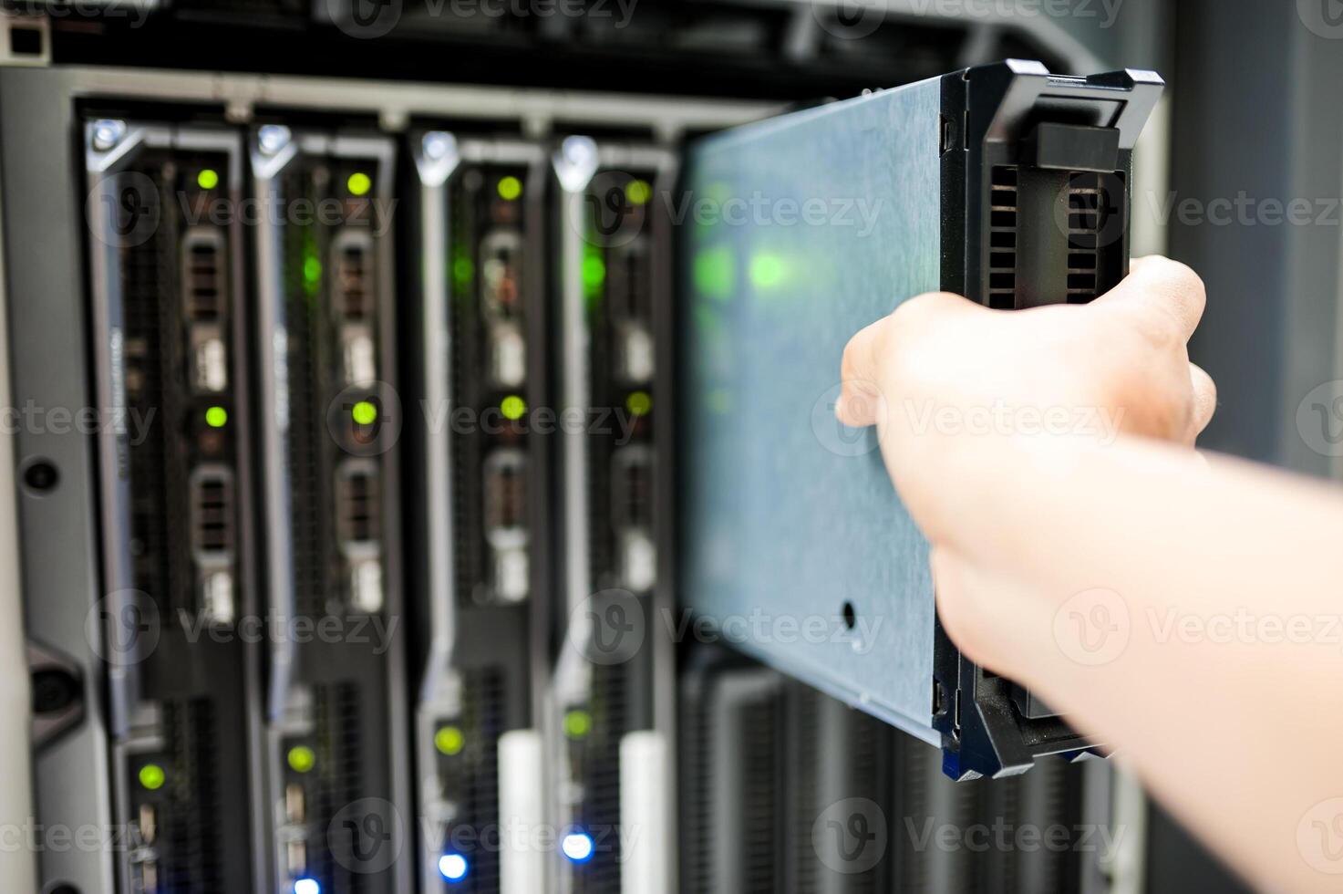 IT engineer repairing a server in a datacenter photo