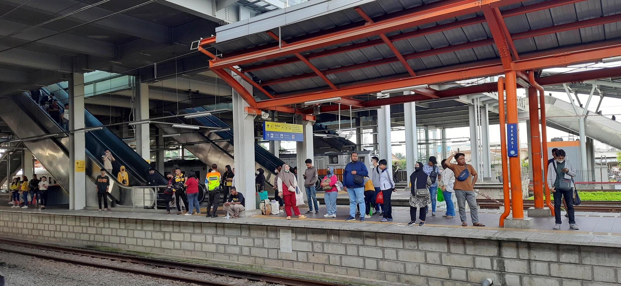 Activity people at railway train station Bekasi. Local train Indonesia. Railway road. West Java, Indonesia - April 8 2024 photo