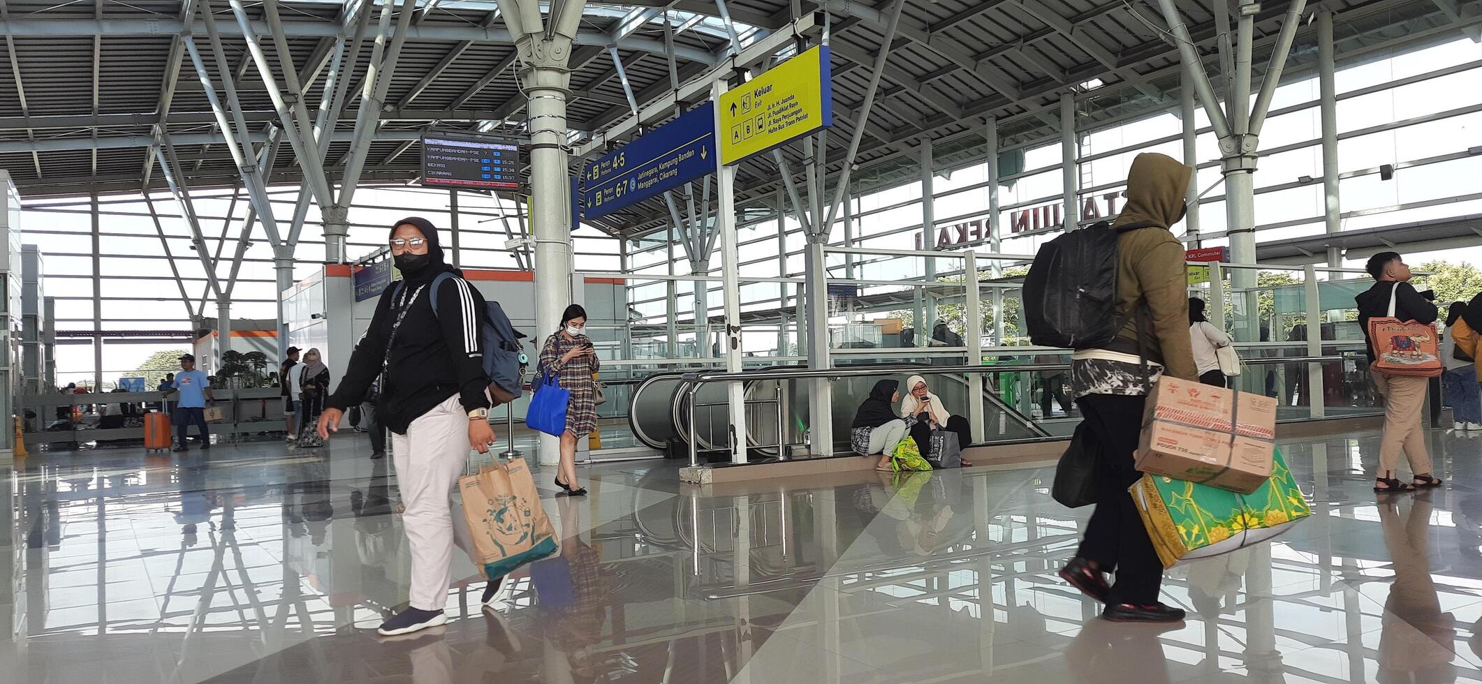 The atmosphere travelers or mudik lebaran or pulang kampung or idul fitri moments in train station Bekasi. West Java, Indonesia - April 8 2024 photo