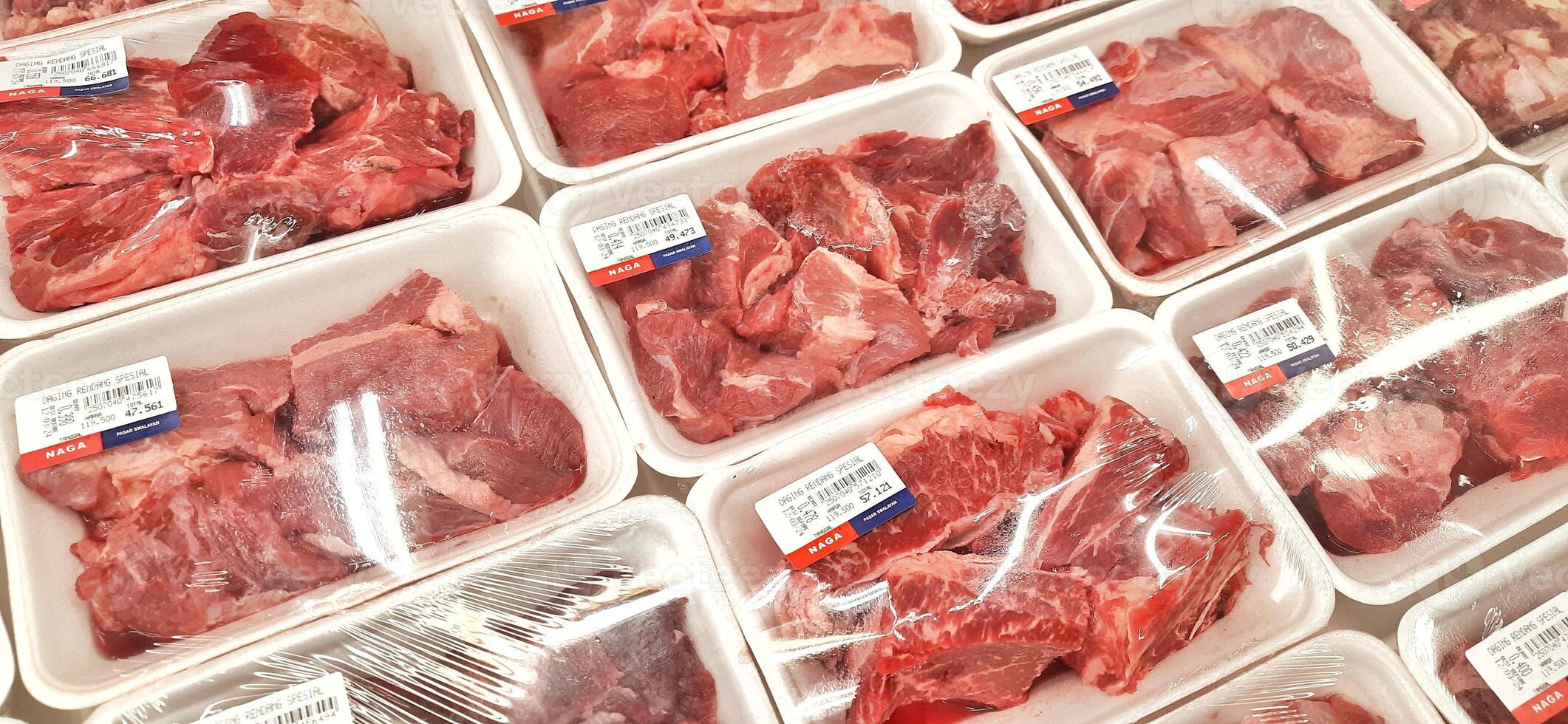 Fresh raw meat chicken and beef on display in supermarket cold shelves. Bekasi, West Java, Indonesia - March 8 2024 photo