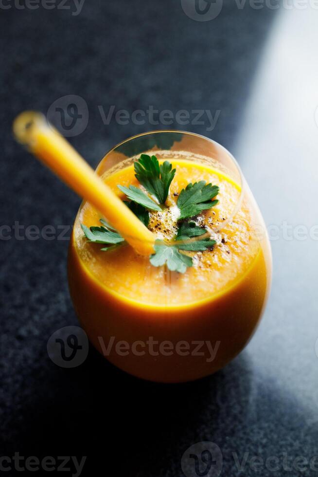 mango Zanahoria manzana zalamero en un vaso en oscuro antecedentes con vaso Paja foto