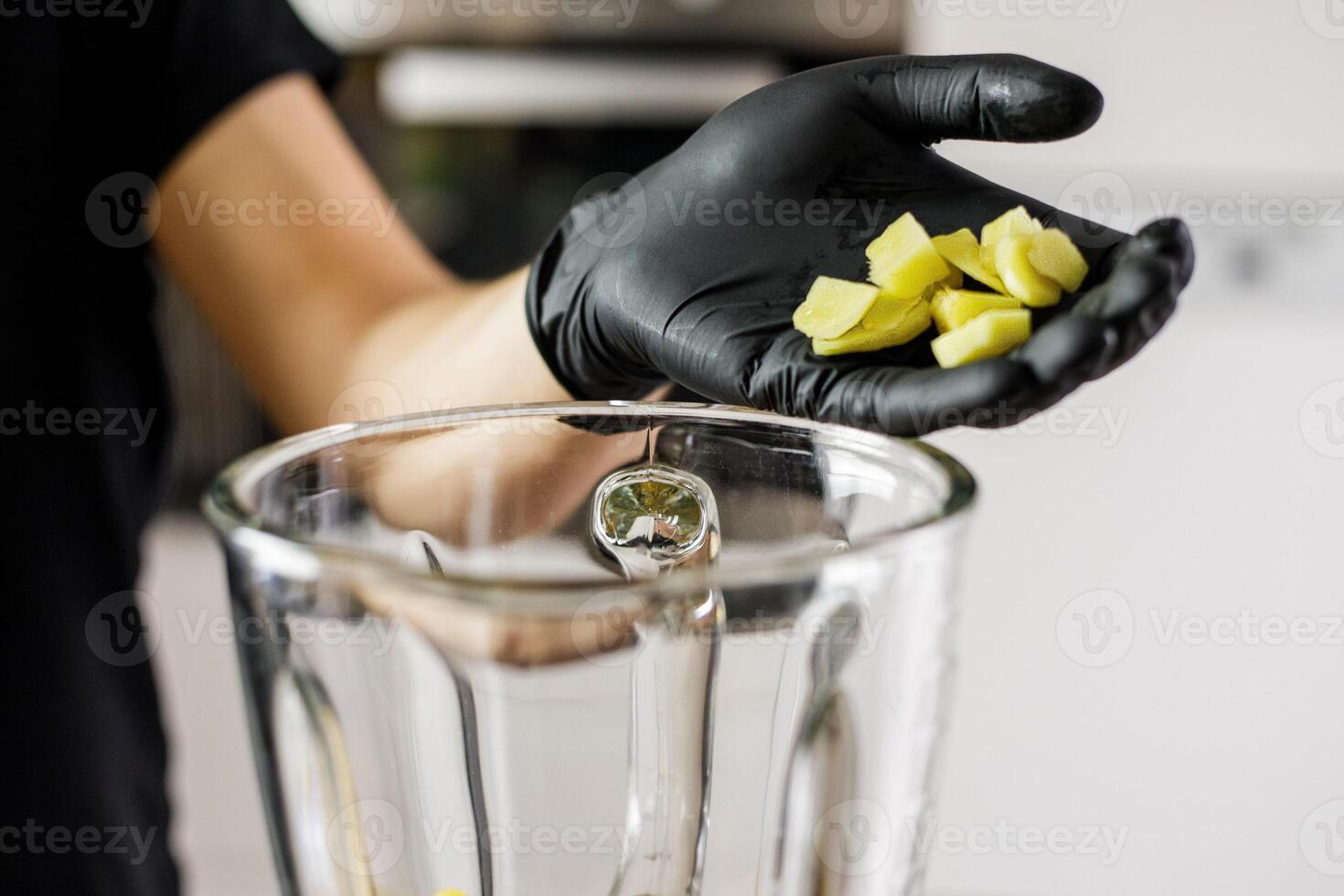 Person with black gloves Peeles and cuts ginger photo