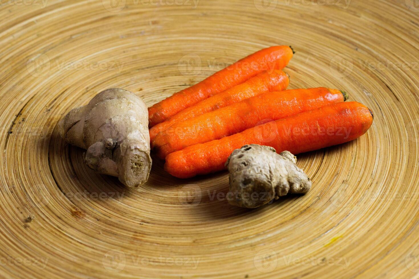 Carots and ginger placed on beatiful wooden tray photo