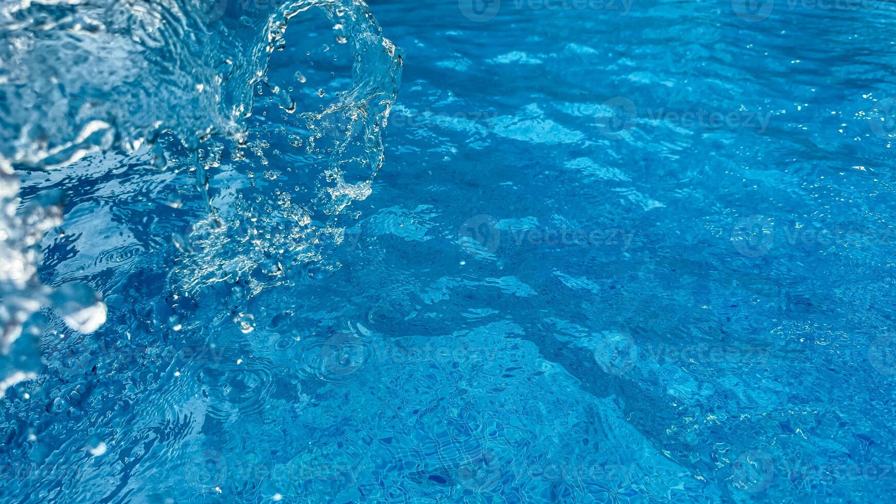 Background dynamic splash of clear water creating swirling wave in blue water with droplets suspended in motion. Clean water concept. photo