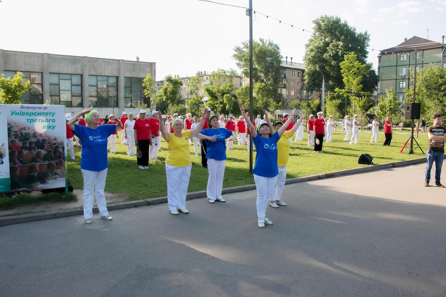 Dnepr, Ukraine - 06.21.2021 A group of elderly people doing health and fitness gymnastics with a ball in the park. photo