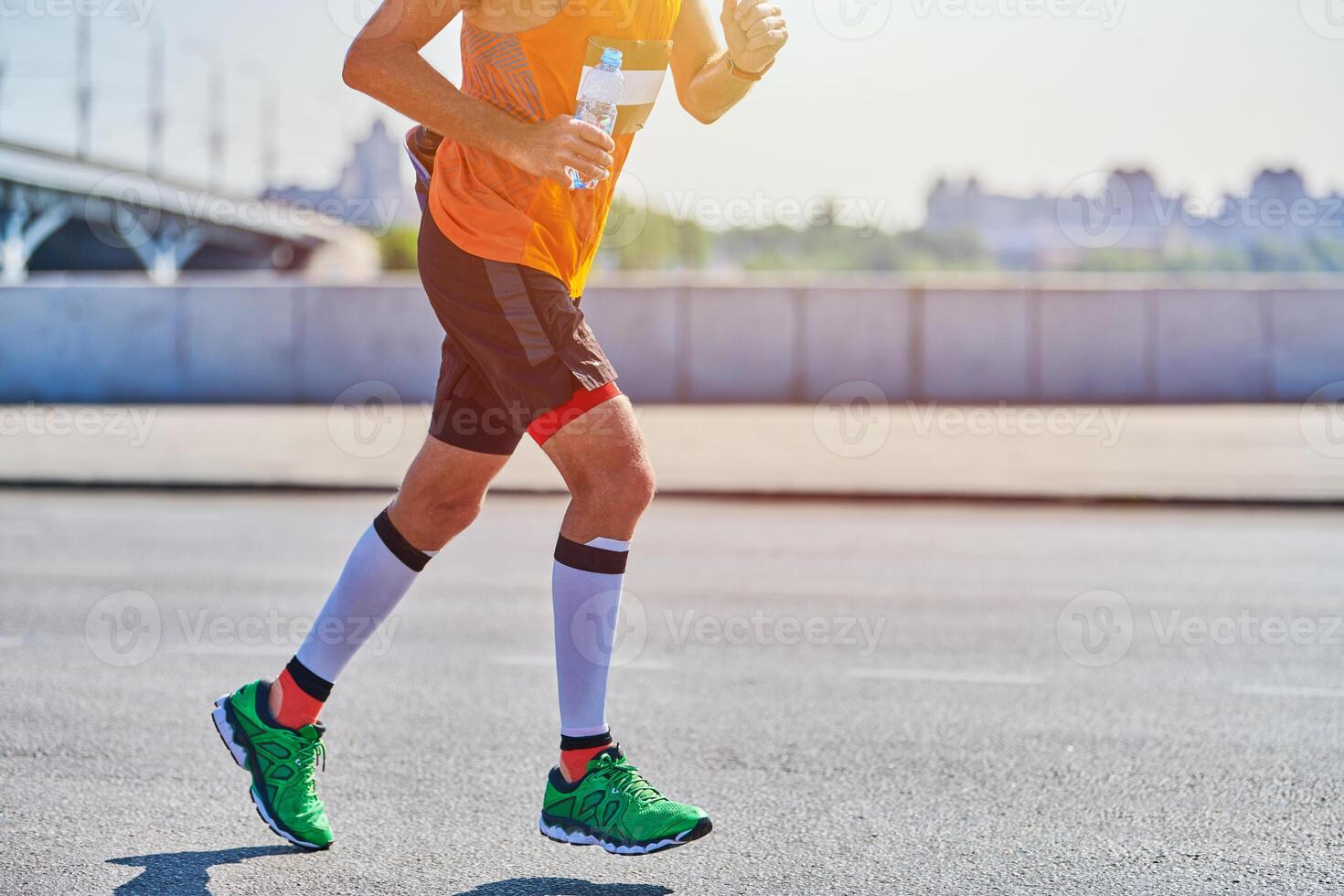 Athletic man jogging in sportswear on city road photo