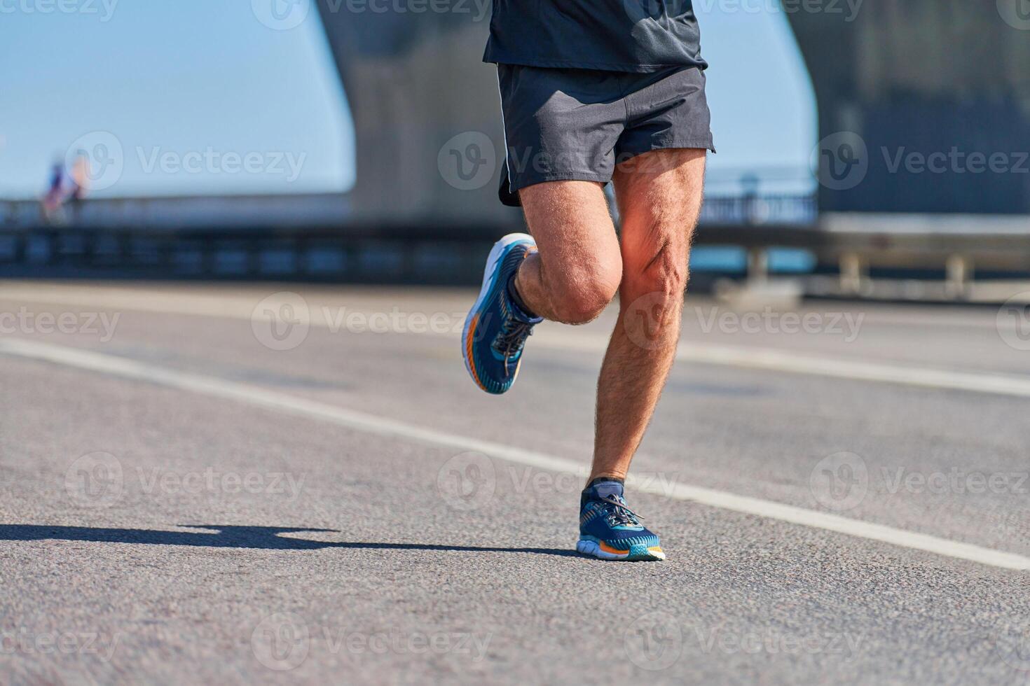 Athletic man jogging in sportswear on city road photo