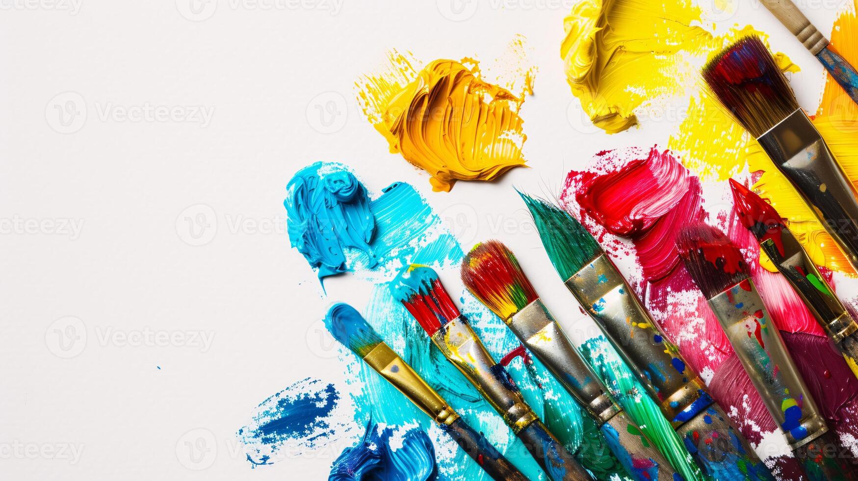 An arrangement of colorful paintbrushes dipped in various hues of paint on a pristine white surface photo