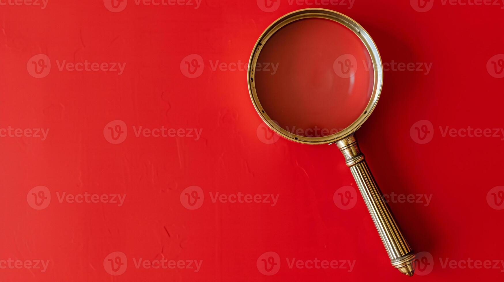 A single antique magnifying glass, placed against a muted colored background, symbolizes curiosity and discovery photo