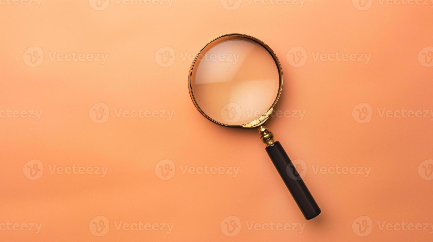 A single antique magnifying glass, placed against a muted colored background, symbolizes curiosity and discovery photo