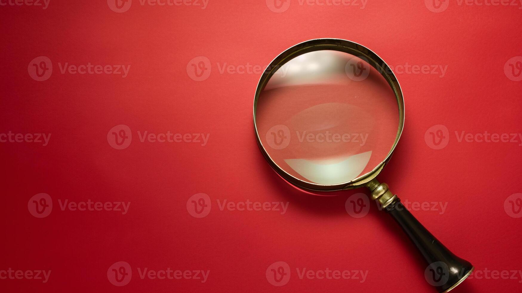 A single antique magnifying glass, placed against a muted colored background, symbolizes curiosity and discovery photo