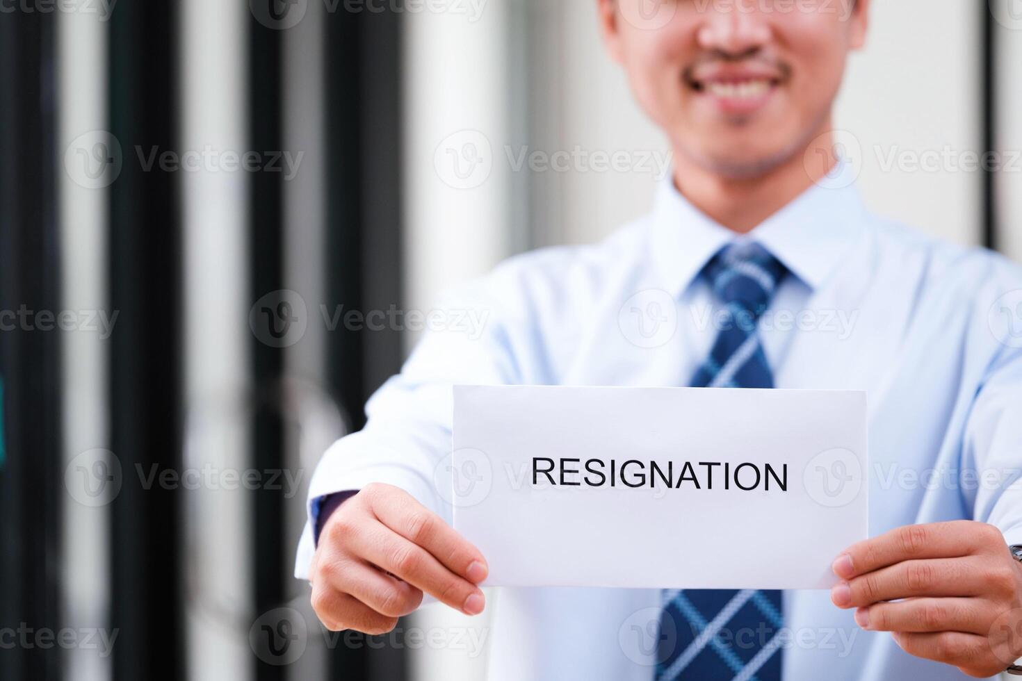 Smiling man displays resignation letter, suggesting a hopeful new beginning. photo