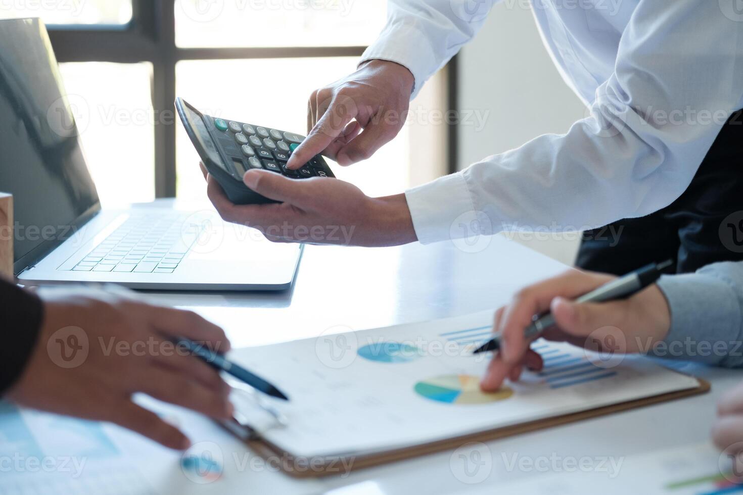 A team of business people is brainstorming to analyze investment project data. photo