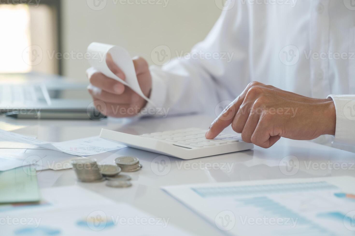 Accountants are using calculators to calculate income, expenses, and investments. photo
