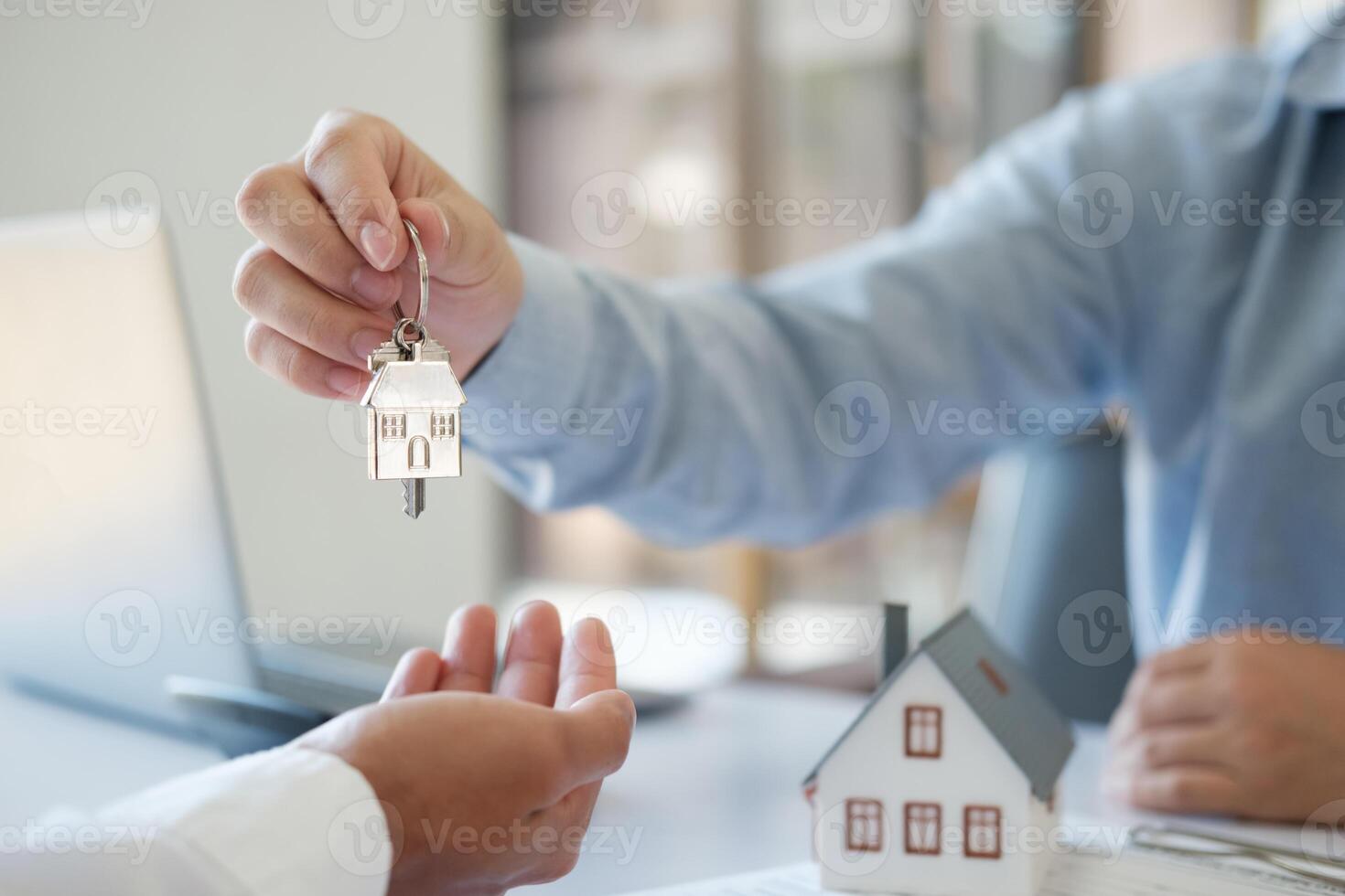 The real estate agent hands the keys to the customer. Real estate investment loans photo