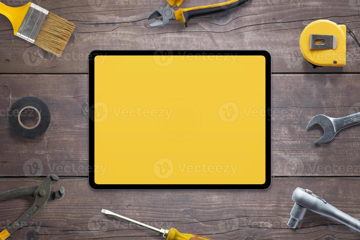 Tablet mockup for app promotion, surrounded by tools on wooden table. Perfect for showcasing your app. Top view, flat lay composition. DIY concept photo