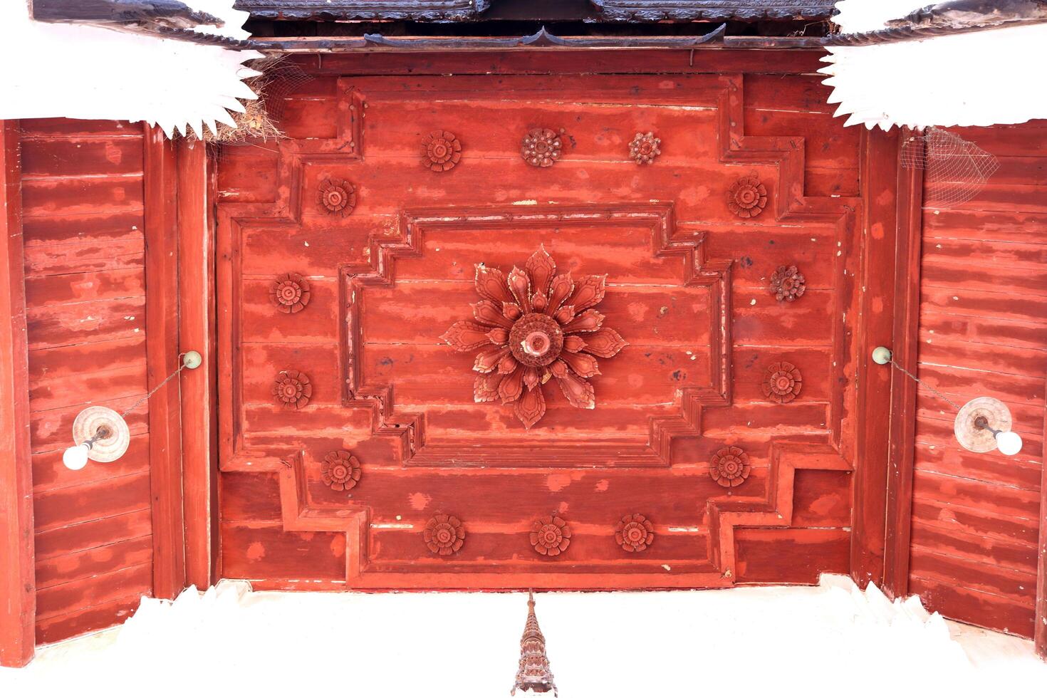 Thai native ancient art on red painted wood ceiling of Buddhism temple in Thailand. photo