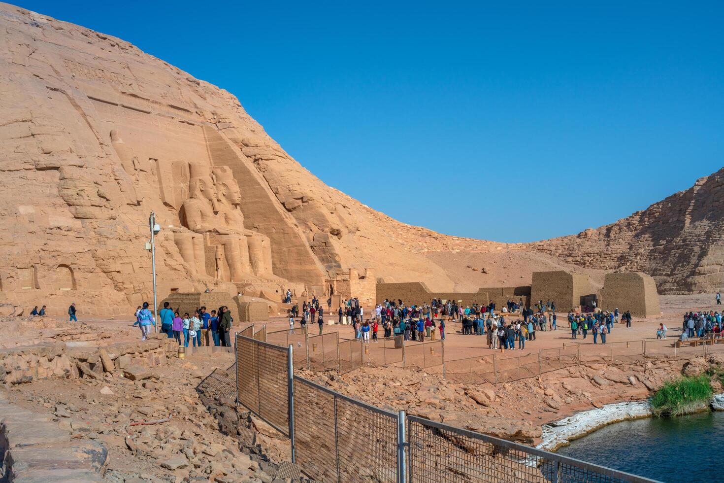 Asuán, Egipto - diciembre 23, 2022 - turistas visitar a abu Simbel templos, a el Entrada a el genial templo de Ramsés ii foto