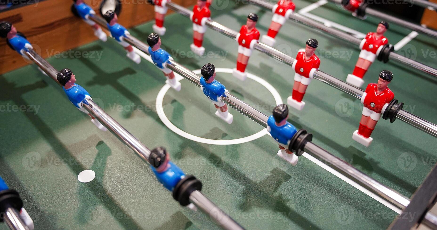 Table football. Green table with little players. Playing football table game. photo