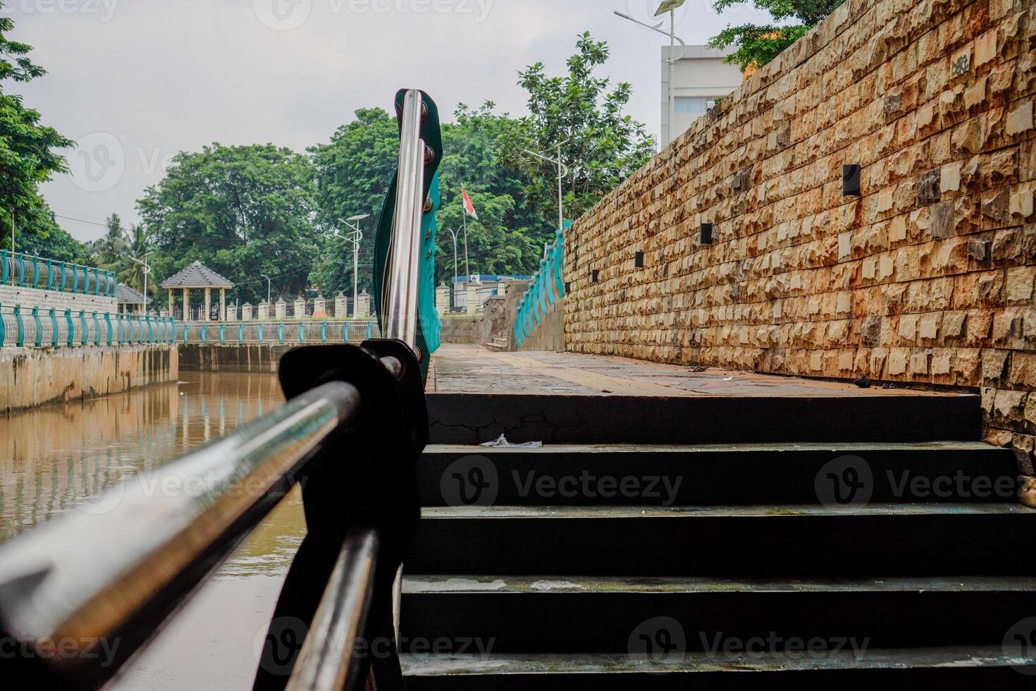 close view of the stairs leading to the garden with the fence dividing the river. photo
