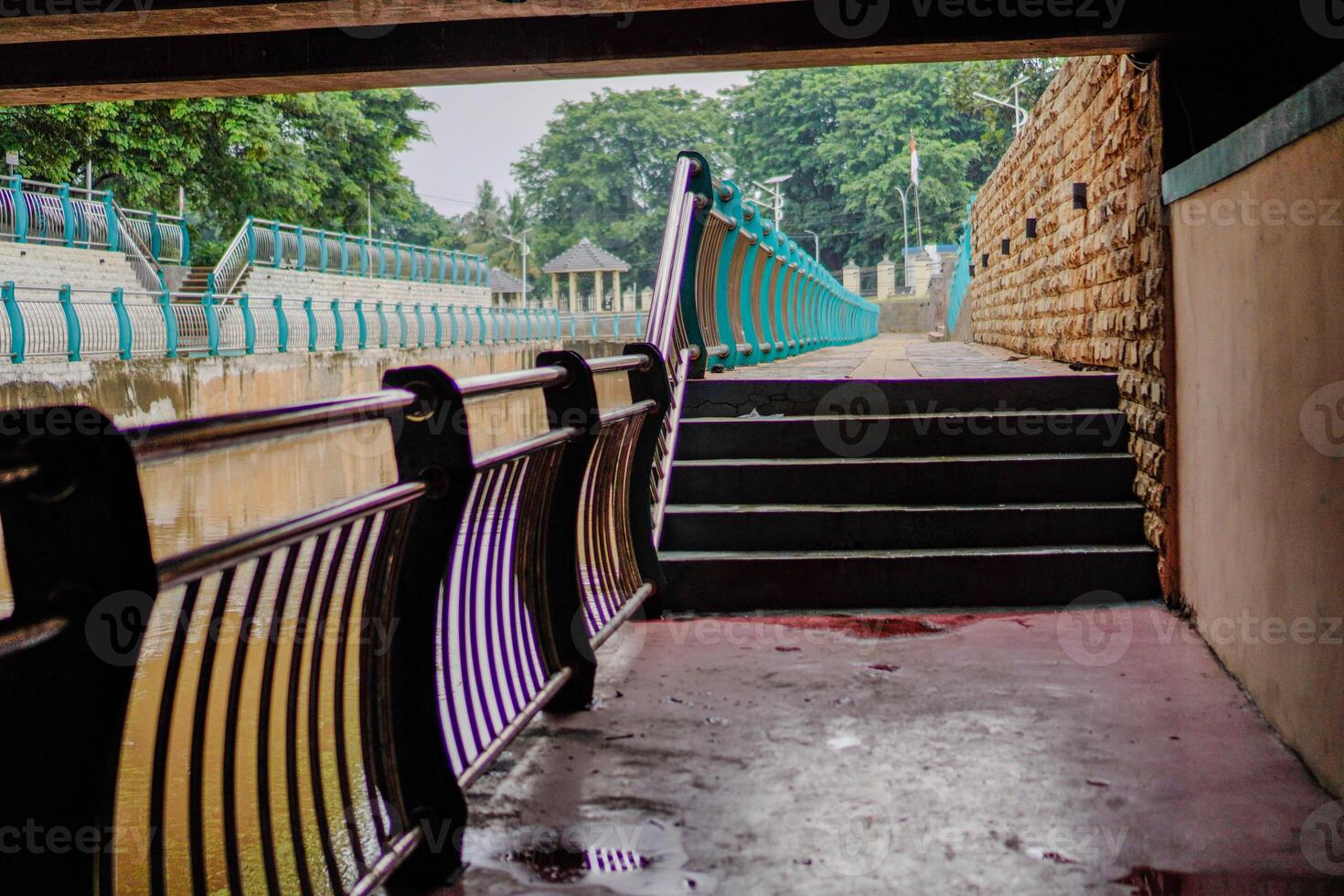 close view of the stairs leading to the garden with the fence dividing the river. photo