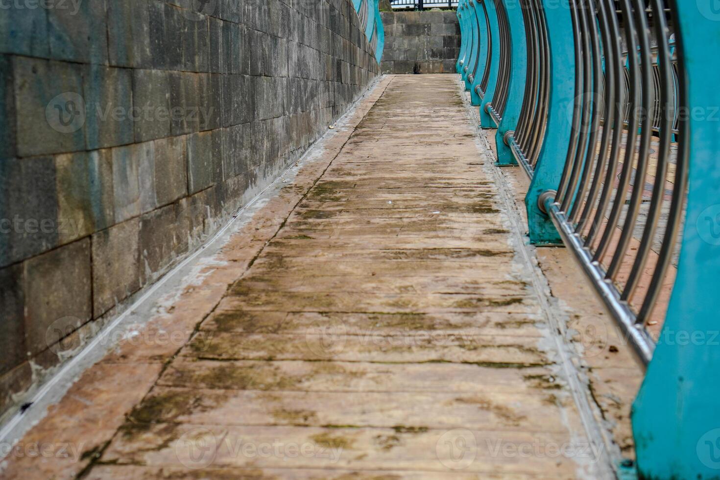 cobblestone paths with many different colors and small stones in the form of tiles with iron guardrails. photo