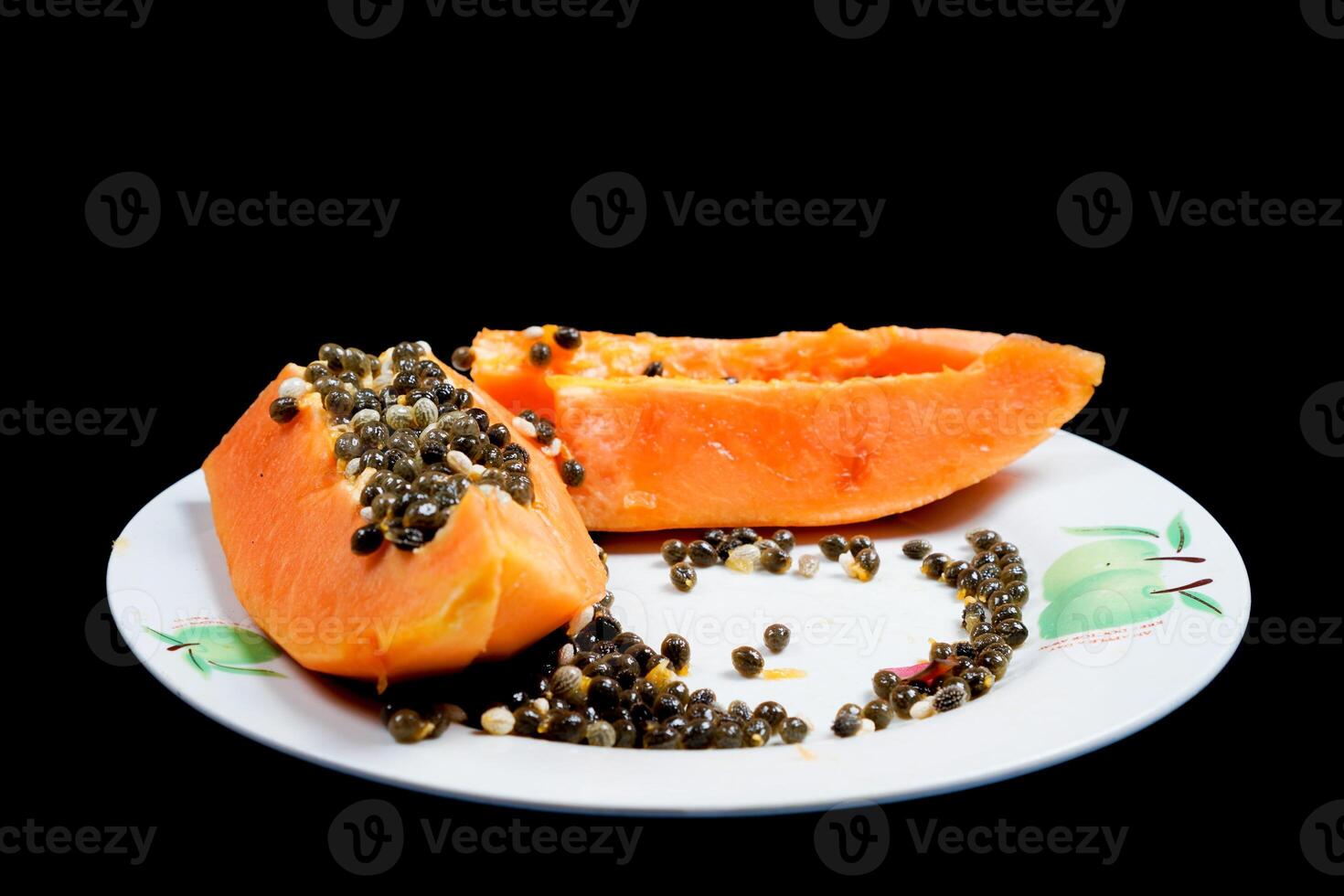 close up view of papaya fruit isolated on plate on black background. photo