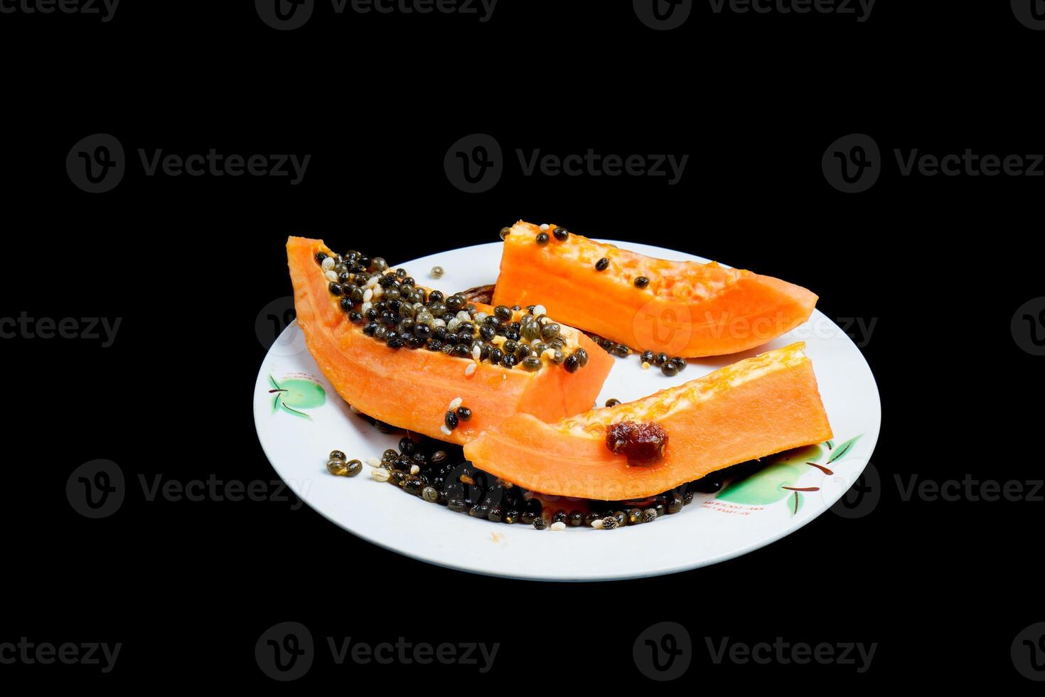 close up view of papaya fruit isolated on plate on black background. photo