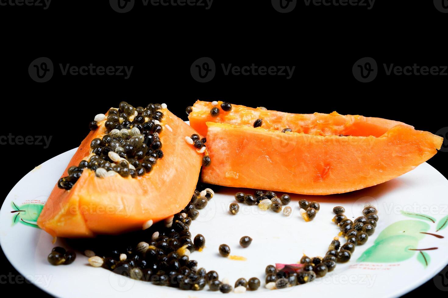 close up view of papaya fruit isolated on plate on black background. photo