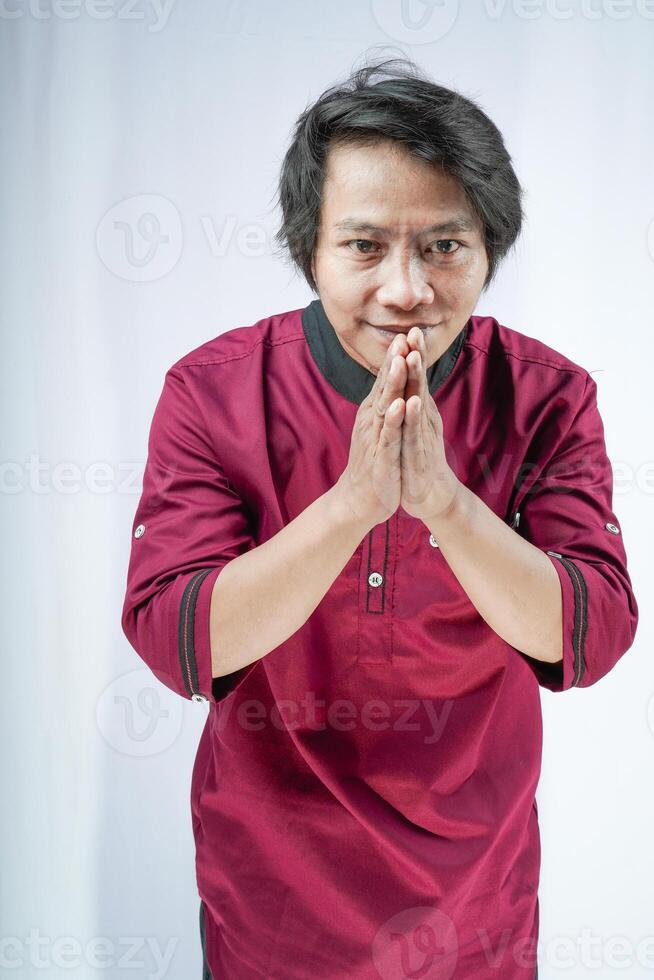 front view of a man wearing a koko shirt giving a salute on a white background. photo