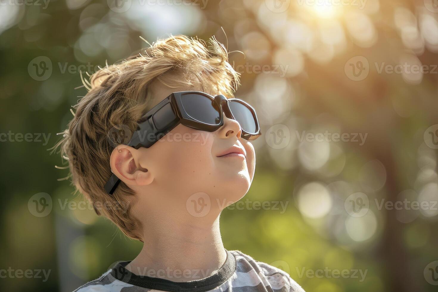 A young boy wearing protective glasses is watching the solar eclipse. photo