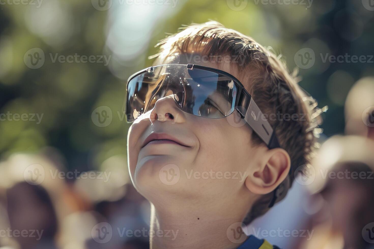 A young boy wearing protective glasses is watching the solar eclipse. photo