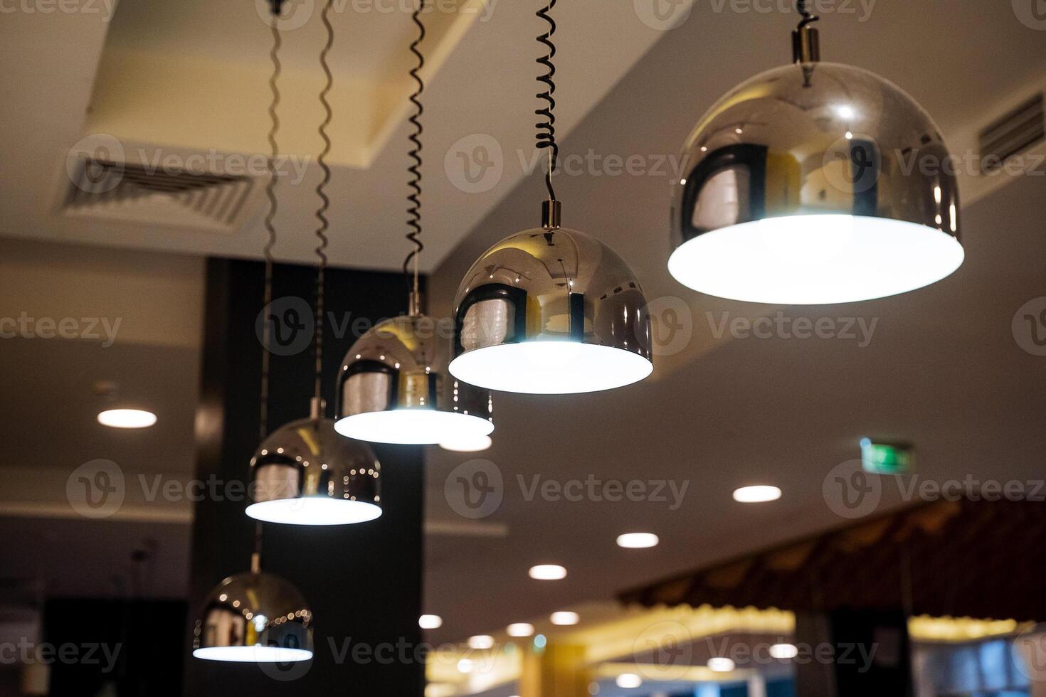 Encendiendo en el restaurante, un brillante pelota de un candelabro colgando desde un estante, diseñador lámparas, un primavera lámpara suspensión. foto