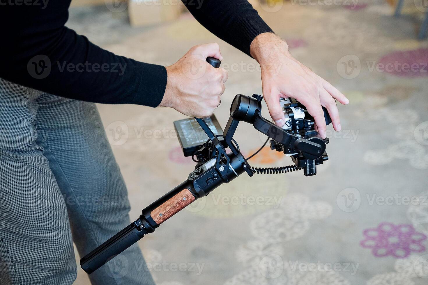 The guy holds the camera stabilizer in his hands, the operator adjusts the photo camera with buttons on the gadget, steadicams for smooth shooting, no image shaking.