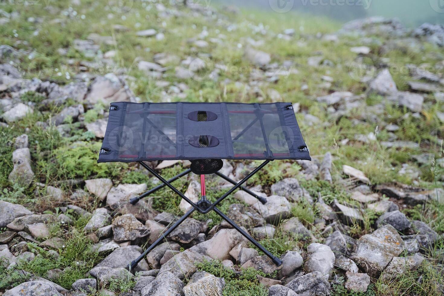 A picnic table stands on the rocks in nature, a frame folding table for food, a park in the mountains, photo